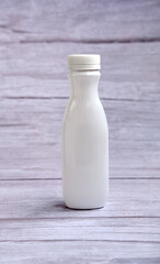 White bottle with a lid on a wooden background