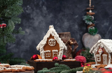 Decorated gingerbread houses christmas cookies with christmas wreath on dark table