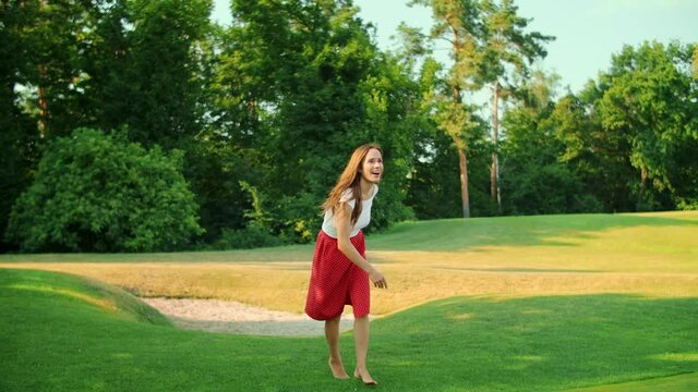 Woman playing frisbee in green meadow. Happy girl having fun in park