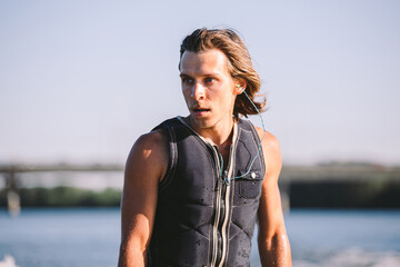 Active wakesurfer jumping on wake board down the river waves. Surfer on wave. Male athlete training...