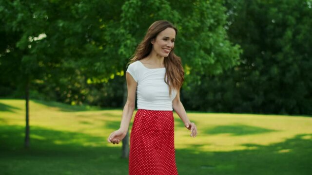Woman throwing frisbee disc in park. Boy and girl taking frisbee disk outdoors