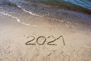 2021 written in the sand on the beach for a happy New Year, copy space, selected focus