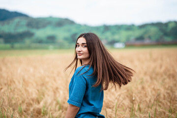 Fototapeta na wymiar Portrait of a girl in a wheat field. Portrait of a beautiful girl in a wheat field.