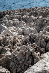 Rocks with Beautiful Texture Falling into Sea on Cap Ferrat Cape in Nice City, France