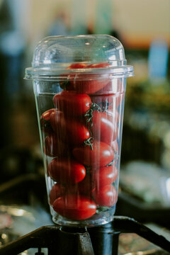 Plastic Cup With Cherry Tomatoes Against The Background Of Bazaar.