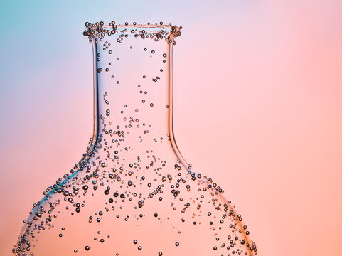 gros plan de verrerie de laboratoire sur fond coloré rose dégradé avec des bulles autour