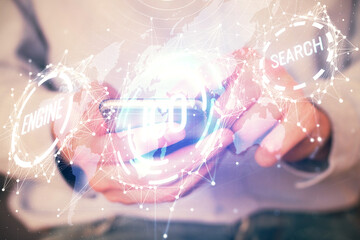 Double exposure of man's hands holding and using a phone and crypto currency blockchain theme...
