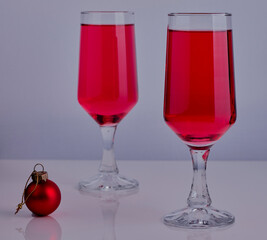 Glasses of red wine shot on a white surface.