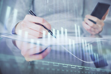 Double exposure of forex chart sketch hologram and woman holding and using a mobile device. Financial market concept.