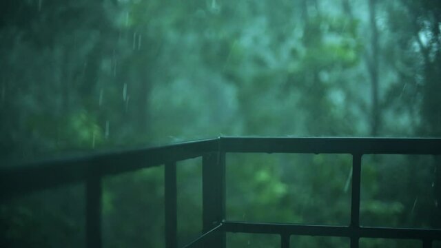 Heavy rain, raindrops hit balcony railing