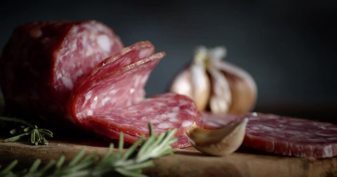Slices of salami with garlic and rosemary slowly rotate.