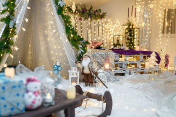 Christmas and New Year decorations with wigwam, fir tree, branches, bulbs, stars and warm garland lights. Winter, December holidays concept.