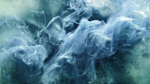 Color smoke background. Ethereal wave. Blue glitter paint flow in water.