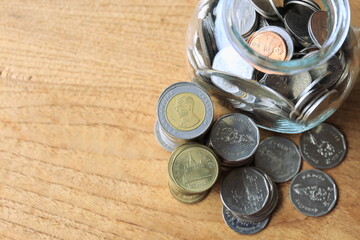 Close-up of many Thai baht coins on a wooden floor selective focus and shallow depth of field