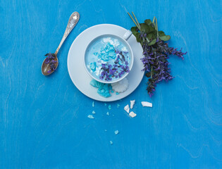 Layout with a Cup of blue moon milk with meringue and Melissa flowers.Top view with space, on a...