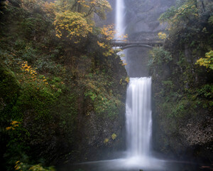 Long exposure a Multnomah waterfalls, Oregon, U.S.A., featuring fall colors and haze from the water