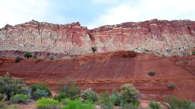 Scenic drive on road panning in slowmo Capitol Reef National Monument point of view of colorful stone red rock in Utah 