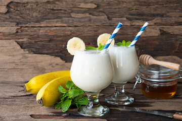 Banana fresh cocktail vanilla smoothies  fruit juice beverage healthy the taste yummy in glass drink episode good morning on wooden background.