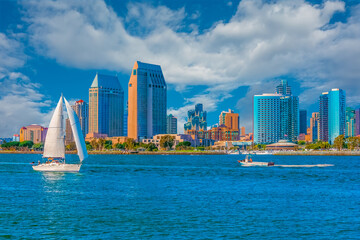 Skyscrapers of San Diego skyline stand behind the San Diego Bay with its boats.