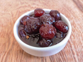 Delicious sweet grooselha with syrup on white bowl.