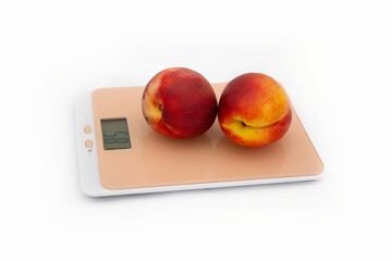 A two peach  on a white background. The concept of weighing