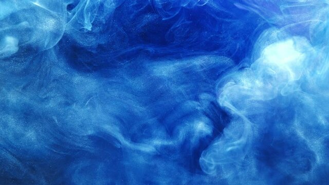 Color smoke background. Magic cloud. Blue white glitter paint motion in water.
