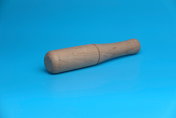 Selective focus of wooden mortar isolated on a blue background.