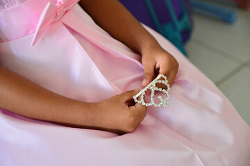 Obraz na płótnie Canvas child's hand holding a crown, princess