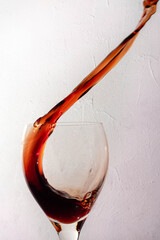 splash de vino en copa de cristal con fondo blanco