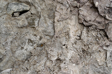 cracked weathered dry stone wall covered with brown clay and sand for texture