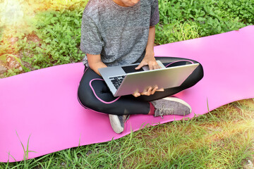 Women use laptops to work on the pink floor at the park. - Powered by Adobe