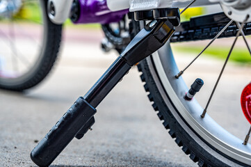 Kick stand holding up a peddle bike with blurred tire in background