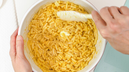 Creamy delicious macaroni and cheese close up in a bowl, view from above