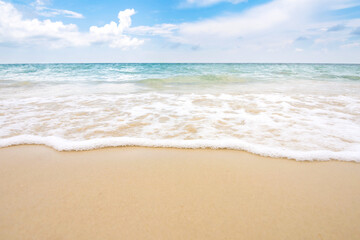 Fototapeta na wymiar Soft ocean wave on sandy beach with blue sky.