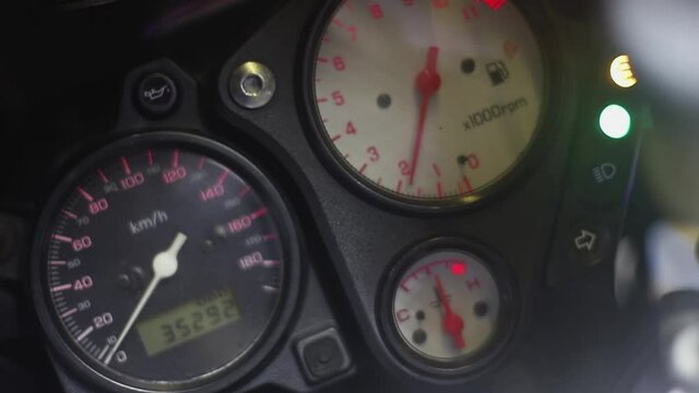 You see the inside of the motorcycle on which there are different instruments - a tachometer, speedometer, red arrows and different lights, and the tachometer arrow changes
