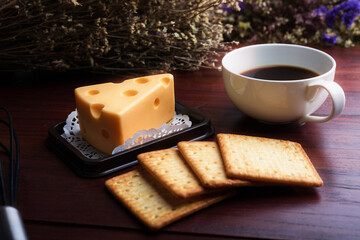 Cheese cake with coffee and biscuit on wooden table.