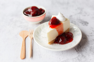 Ice box cheese cake with strawberry jam and whipping cream on white background.