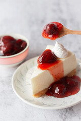 Ice box cheese cake with strawberry jam and whipping cream on white background.