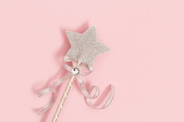 Glowing, glittering star on pink background with copy space. Magic star, fulfillment of wishes, dreams. Romantic atmosphere concept. Minimal style.