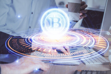 Crypto currency theme hologram with businessman working on computer on background. Concept of...