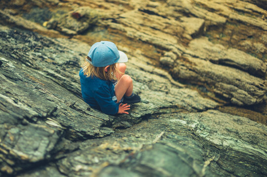 Preschooler boy climbing on rocks
