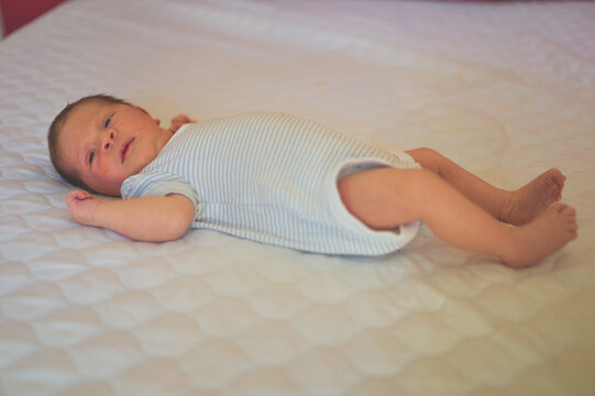 Newborn baby lying on a bed