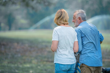 Elderly couple walking together in the park for health care and relax.