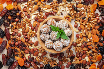 Sweet protein vegan balls in a bowl and various nuts and dried fruits. Homemade sugar free candy....