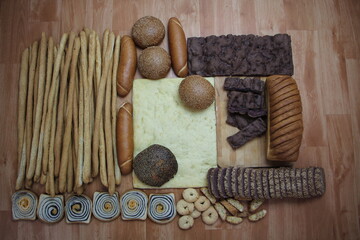 Fototapeta na wymiar breadsticks, bread, rolls, pizza on wooden background
