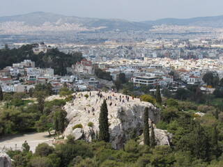 Fototapeta na wymiar View over Athens from the Acropolis with the Areopagus Hill (or Mars Hill) with many tourists