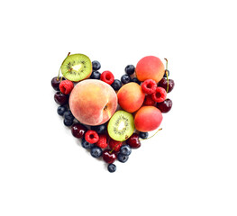 Heart made of whole and halved fruits and berries over white. Organic superfood concept for healthy eating