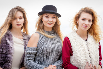 Fototapeta premium Three fashionable woman against sky