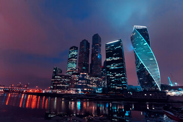 High modern skyscrapers of Moscow city with lighting and reflection in the river