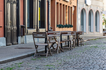 Outdoor cafe with chairs, outdoor restaurant. Ancient architecture, narrow streets and cobblestone pavement.